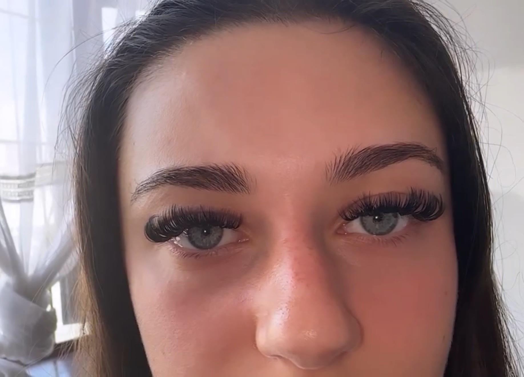 Refined volume lash extensions framing pale blue eyes